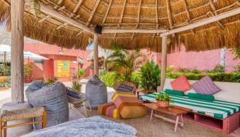 Selina Cancun Laguna Hotel Zone chill area. Gay-friendly hotel with thatched roof, bean bags, and comfy seating in Cancun's Hotel Zone.