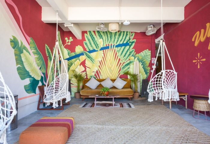 Selina Cancun Laguna Hotel Zone's chill area: colorful murals, hanging chairs, & comfy seating. A gay-friendly hotel in Cancun's Hotel Zone.