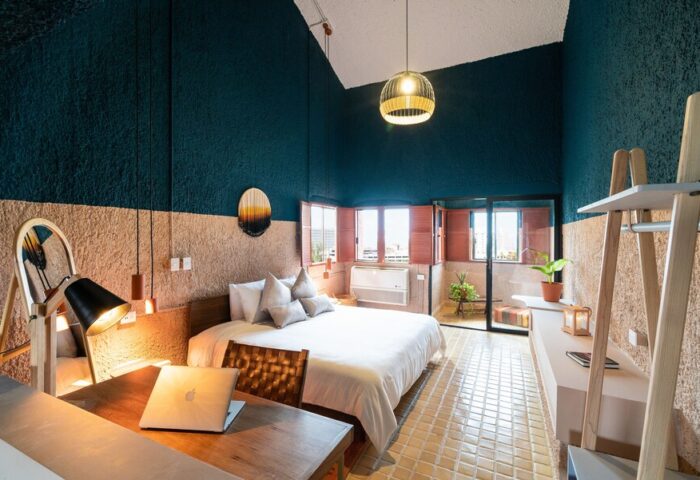 Selina Cancun Laguna Hotel Zone gay-friendly room. Modern design, laptop on desk, bed, and balcony. Ideal for LGBTQ+ travelers.