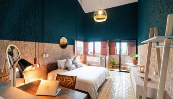 Selina Cancun Laguna Hotel Zone gay-friendly room. Modern design, laptop on desk, bed, and balcony. Ideal for LGBTQ+ travelers.