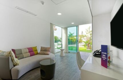 Seven Hotel & Wellness gay men only: Stylish room interior with curved sofa, garden view. Gay-friendly hotel for gay men's travel.