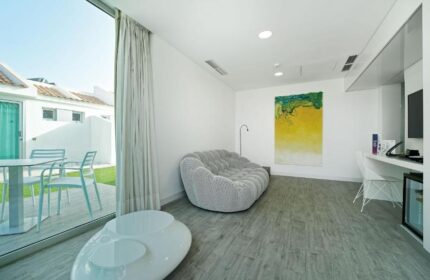 Seven Hotel & Wellness room interior. Gay men only hotel with modern design, patio view, and comfortable seating. Gay-friendly hotel room.