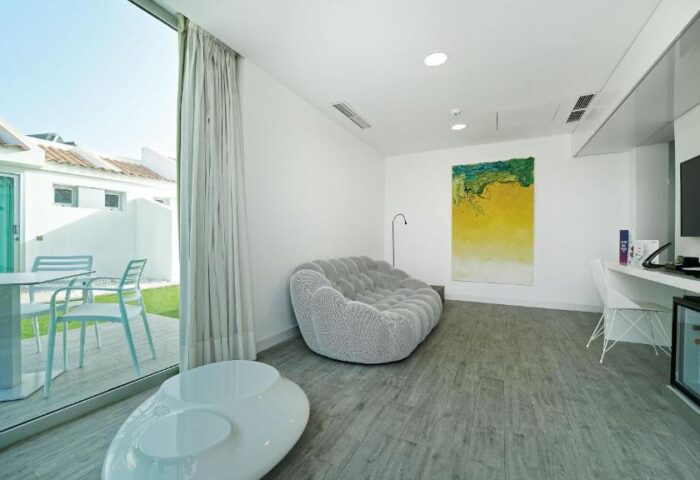 Seven Hotel & Wellness room interior. Gay men only hotel with modern design, patio view, and comfortable seating. Gay-friendly hotel room.