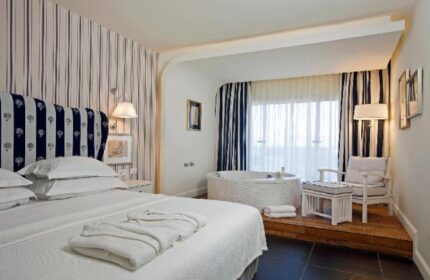 Shalom Hotel & Relax room, an Atlas Boutique Hotel. Gay-friendly, pet-friendly hotel room with bed, jacuzzi, and striped decor.