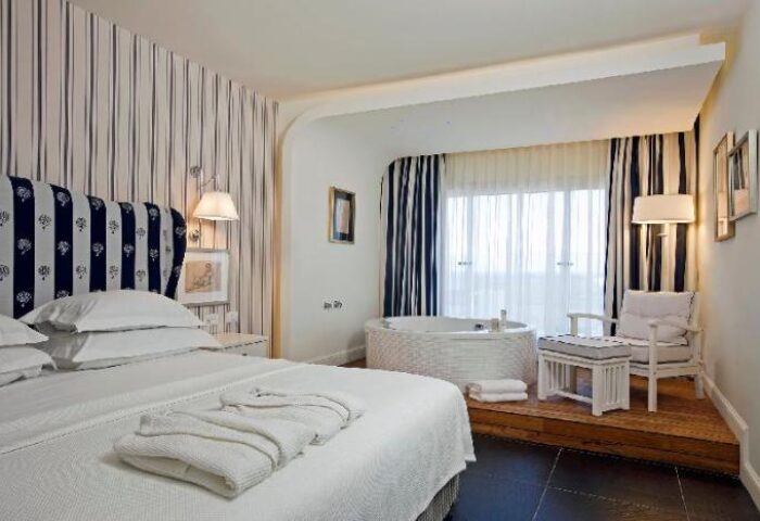 Shalom Hotel & Relax room, an Atlas Boutique Hotel. Gay-friendly, pet-friendly hotel room with bed, jacuzzi, and striped decor.