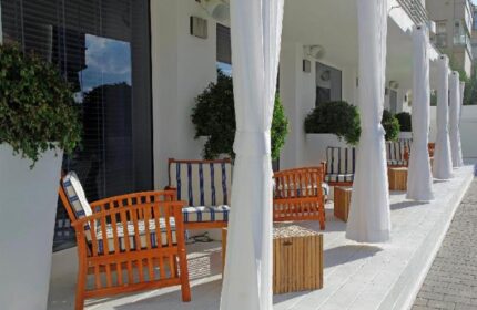 Shalom Hotel & Relax, an Atlas Boutique Hotel. Gay-friendly, pet-friendly hotel patio with white curtains and wood furniture.
