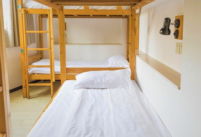 Shanghai Blue Mountain Youth Hostel Luwan dorm room. Gay-friendly hotel with bunk beds, white linens, and a reading light. Budget travel.