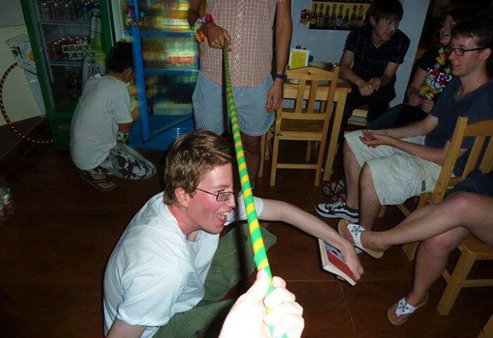 Gay-friendly Shanghai Blue Mountain Youth Hostel Luwan: Men play limbo at the hotel. A fun, inclusive travel experience in Shanghai, China.