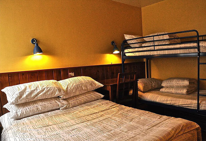 Bedroom at Shanghai Le Tour Traveler's Rest Youth Hostel. Gay-friendly hotel with bunk beds, desk, and warm lighting. Budget lodging for gay travelers.