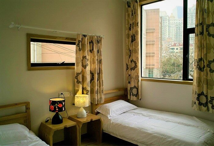 Shanghai Rock & Wood International Youth Hostel room. Twin beds, lamps, and window views. A gay-friendly hotel in Shanghai, China.