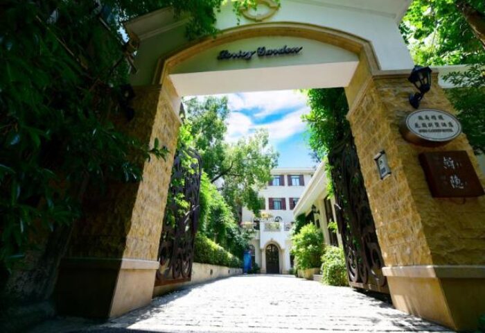 Entrance to Shanghai Soho Garden Hotel, a gay-friendly hotel. Stone archway, lush greenery. A welcoming space for gay travelers in Shanghai.