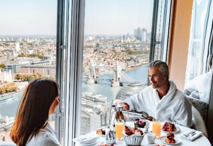 Gay-friendly Shangri-La Hotel At The Shard: Couple in bathrobes enjoys breakfast with a view of London and Tower Bridge from their room.