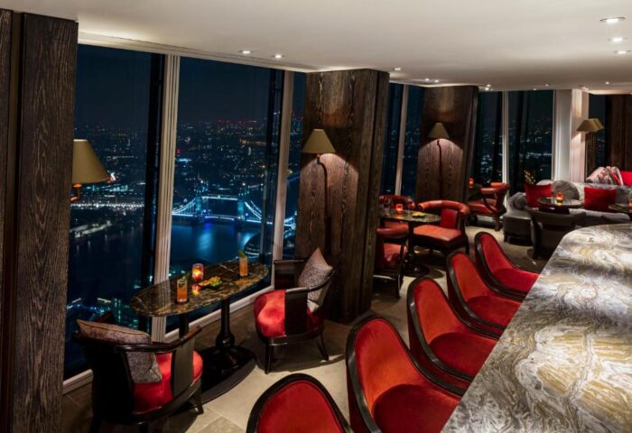 Gay-friendly Shangri-La Hotel At The Shard bar interior at night. Tower Bridge view from London hotel. Upscale gay travel.