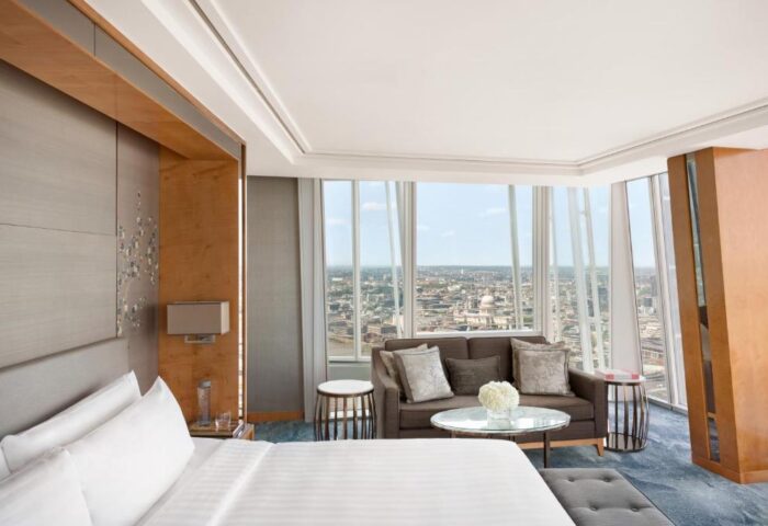 Shangri-La Hotel At The Shard gay-friendly suite view. Modern room with bed, sofa, and London skyline. Luxury hotel for gay travel.