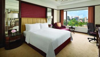 Gay-friendly Shangri La Hotel Kuala Lumpur room. Luxurious interior, large bed, city view. Ideal for gay travelers seeking comfort & style.