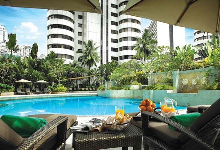 Shangri-La Hotel Kuala Lumpur pool view. Gay-friendly hotel with poolside relaxation, breakfast, and lush greenery. Perfect for gay travel.