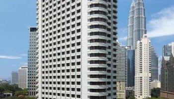 Shangri-La Hotel Kuala Lumpur, a gay-friendly hotel. Exterior view of the high-rise building with the Petronas Towers in the background.