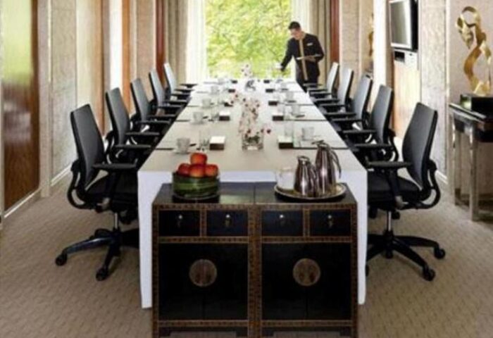 Shangri-La Hotel Kuala Lumpur boardroom. Long table set for meeting. Gay-friendly hotel with modern amenities. Staff member visible.