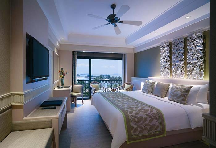 Shangri-La's Rasa Sentosa Resort & Spa gay-friendly hotel room. Balcony with sea view, king bed, TV, and decorative wall art.