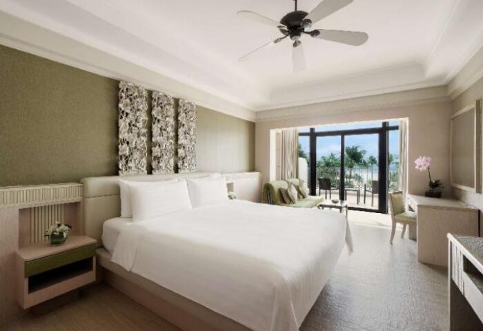 Shangri-La's Rasa Sentosa Resort & Spa room. Gay-friendly hotel with a king bed, balcony, and ocean view. Luxury travel.