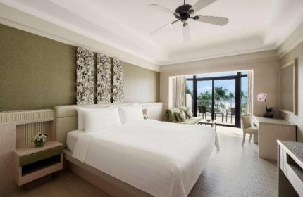 Shangri-La's Rasa Sentosa Resort & Spa room. Gay-friendly hotel with a king bed, balcony, and ocean view. Luxury travel.