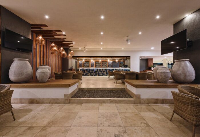 Sheraton Buganvilias Resort lobby interior. Gay-friendly hotel in Puerto Vallarta, Mexico. Rattan chairs, large vases, & modern design.