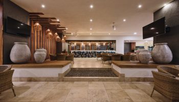 Sheraton Buganvilias Resort lobby interior. Gay-friendly hotel in Puerto Vallarta, Mexico. Rattan chairs, large vases, & modern design.