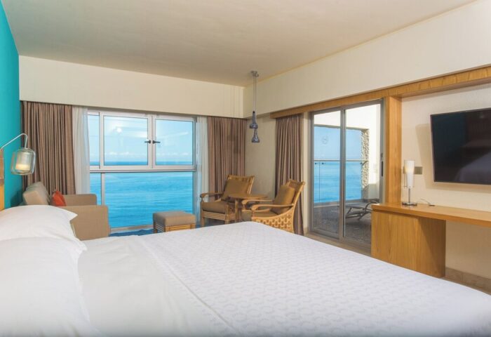 Gay-friendly Sheraton Buganvilias Resort room. Ocean view, balcony, chairs, and TV. A great hotel for gay men traveling to Puerto Vallarta.