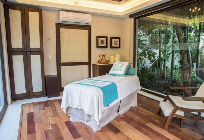 Spa room at Sheraton Buganvilias Resort & Convention Center, a gay-friendly hotel. Massage table, wood floors, & garden view. Relaxing getaway.