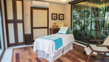 Spa room at Sheraton Buganvilias Resort & Convention Center, a gay-friendly hotel. Massage table, wood floors, & garden view. Relaxing getaway.