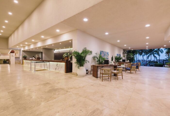 Lobby at Sheraton Buganvilias Resort & Convention Center, a gay-friendly hotel. Reception desk, seating area, and view of palm trees.