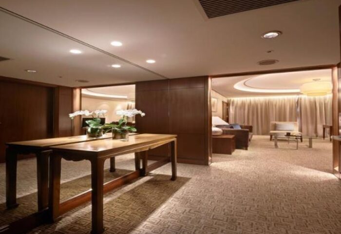 Sheraton Grand Taipei Hotel room. Gay-friendly hotel with tables, flowers, and a view into the living area. Luxury Taiwan travel.