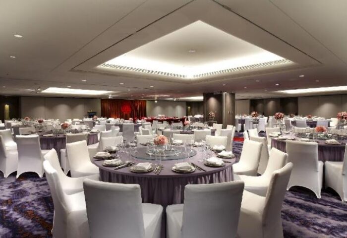 Sheraton Grand Taipei Hotel ballroom setup for an event. Gay-friendly hotel with round tables, white chairs, and elegant decor.