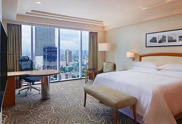 Sheraton Manila Bay gay-friendly hotel room. Desk, bed, and city view. Modern design, comfortable stay. Manila travel for gay men.