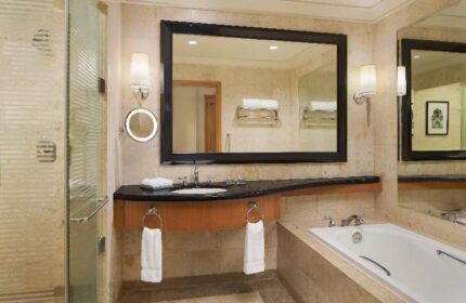 Sheraton Manila Bay gay-friendly hotel bathroom. Features a shower, large mirror, sink, and bathtub. Upscale design for gay men travelers.