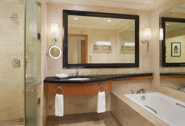 Sheraton Manila Bay gay-friendly hotel bathroom. Features a shower, large mirror, sink, and bathtub. Upscale design for gay men travelers.