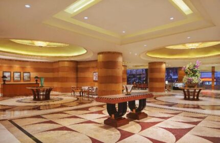 Sheraton Manila Bay lobby. Gay-friendly hotel with elegant interior design, featuring marble floors, wood paneling, and stylish furnishings.