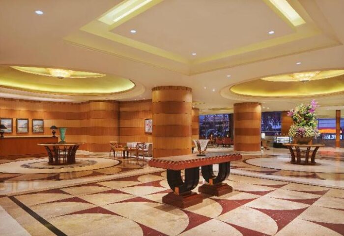 Sheraton Manila Bay lobby. Gay-friendly hotel with elegant interior design, featuring marble floors, wood paneling, and stylish furnishings.