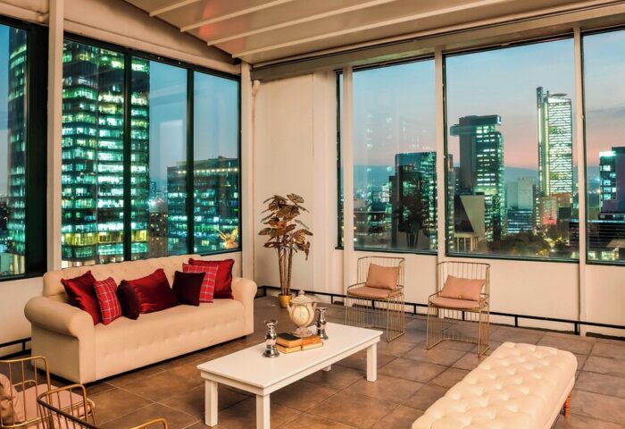 Sheraton Mexico City Maria Isabel Hotel's gay-friendly suite. Cityscape view from the suite's window. Modern design, comfortable seating.