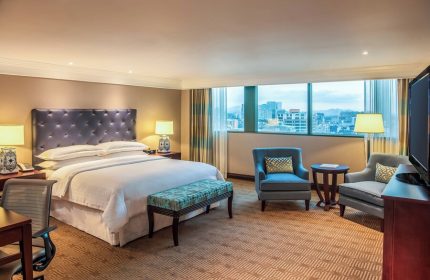 Gay-friendly Sheraton Mexico City Maria Isabel Hotel room. King bed, city view, chairs, and desk. Upscale accommodations for gay travelers.