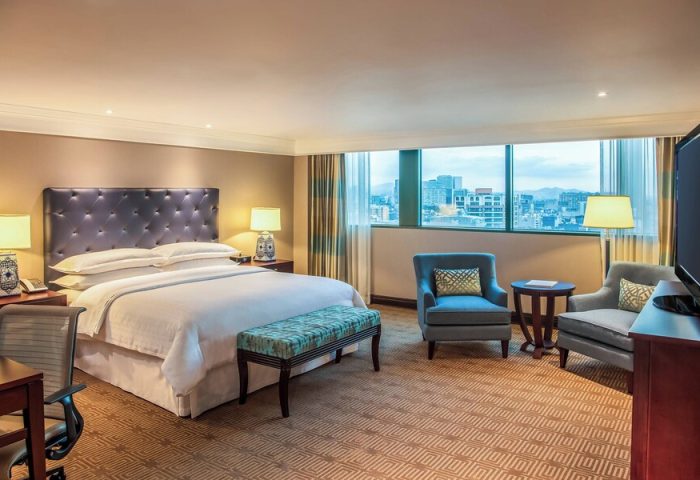 Gay-friendly Sheraton Mexico City Maria Isabel Hotel room. King bed, city view, chairs, and desk. Upscale accommodations for gay travelers.