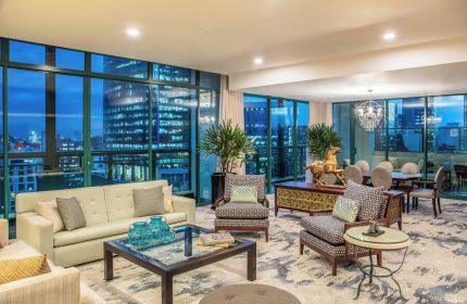 Sheraton Mexico City Maria Isabel Hotel suite. Gay-friendly hotel room with city views, sofa, chairs, table, and dining area. Upscale decor.