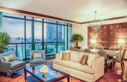 Gay-Friendly Sheraton Mexico City Maria Isabel Hotel room. Living area with city view, sofa, chairs, and dining table. Upscale hotel for gay travelers.