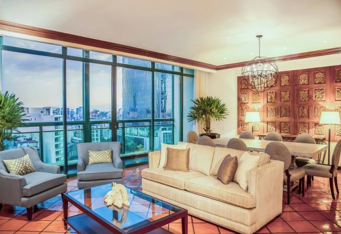 Gay-Friendly Sheraton Mexico City Maria Isabel Hotel room. Living area with city view, sofa, chairs, and dining table. Upscale hotel for gay travelers.