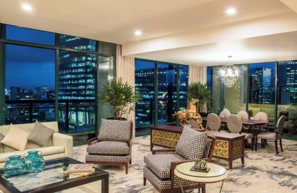 Gay-Friendly Sheraton Mexico City Maria Isabel Hotel suite at night. City views, stylish furniture, and a welcoming atmosphere.