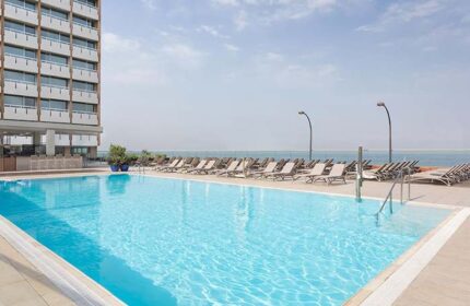 Sheraton Tel Aviv Hotel pool. Gay-friendly, pet-friendly hotel with ocean views. Loungers line the pool deck for sunbathing. Perfect for gay travel.