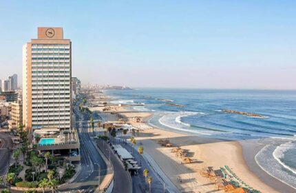 Gay-friendly Sheraton Tel Aviv Hotel, a pet-friendly beachfront property. View of the hotel tower, beach, and Mediterranean Sea. Tel Aviv gay travel.