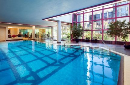 Indoor pool at the gay-friendly Sheraton Vancouver Wall Centre hotel. Gym equipment visible. Great for gay men's travel.