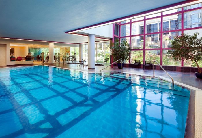 Indoor pool at the gay-friendly Sheraton Vancouver Wall Centre hotel. Gym equipment visible. Great for gay men's travel.