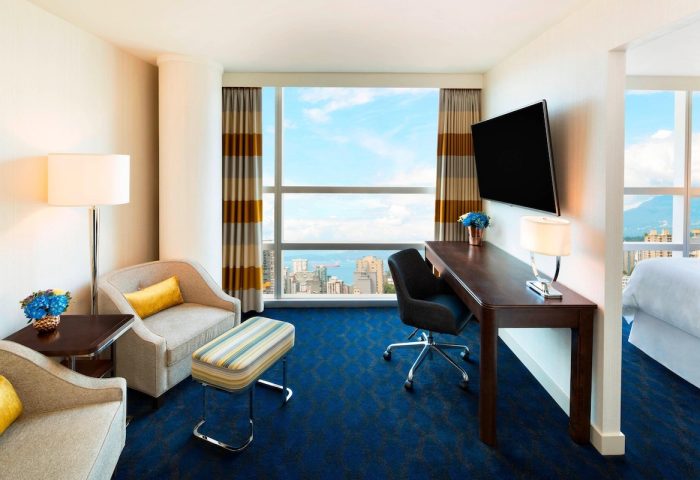 Sheraton Vancouver Wall Centre gay-friendly hotel room. Seating area, desk, TV, and a view of the city. Modern design, comfortable stay.